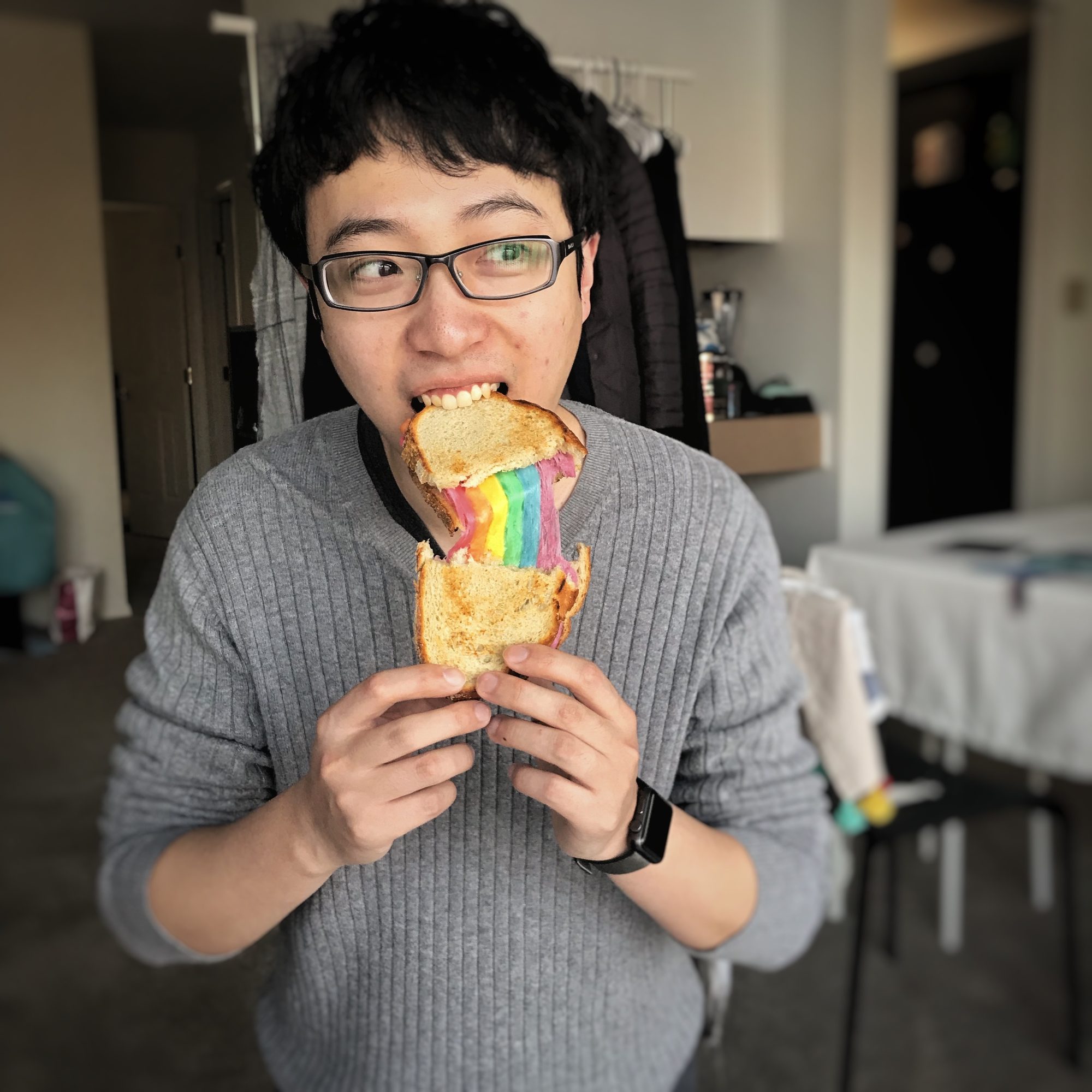 A photo of Qinan eating a rainbow bread