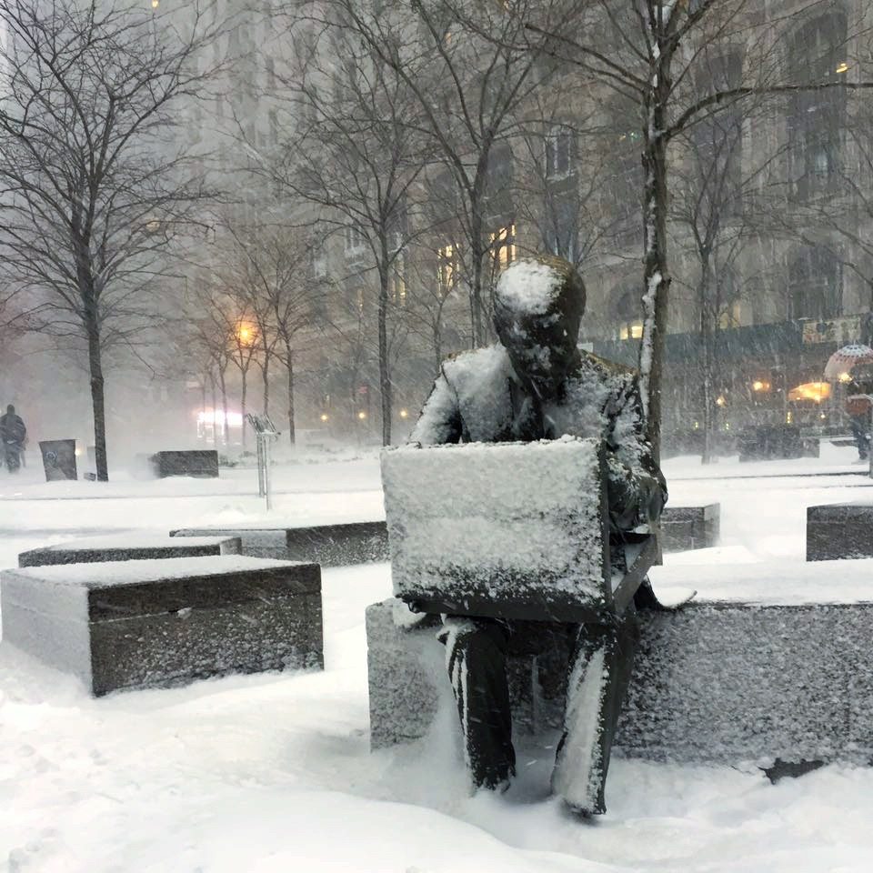 A sculpture of a man working on a laptop in the snow